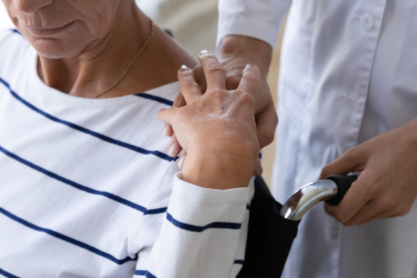 Female nurse carer paramedic support disabled senior adult grandma patient sit on wheelchair put hand on shoulder help old paralyzed lady, elder disability handicap assistance concept, close up view