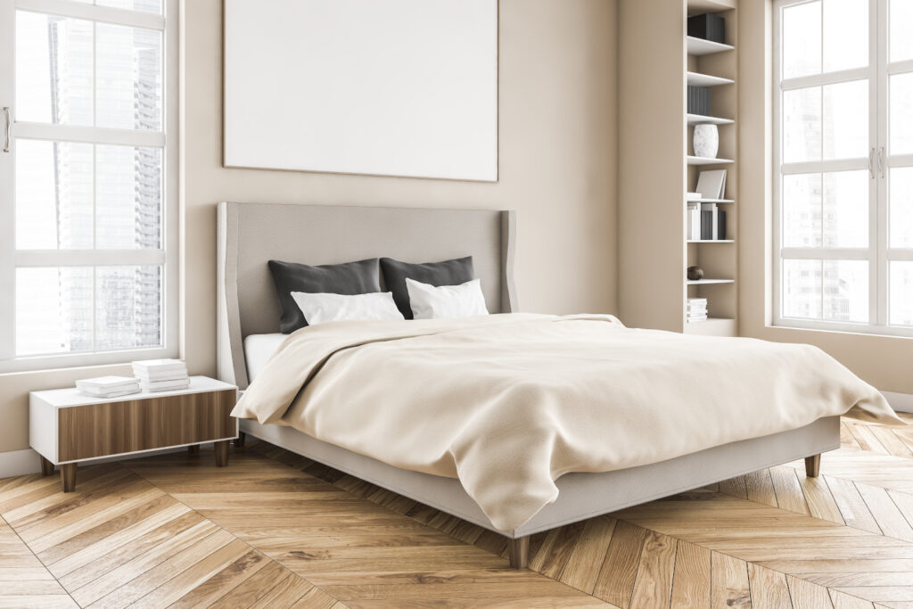 Wooden living room with mockup frame over the bed with linens on parquet floor, side view. Light brown minimalist bedroom with shelves and books. Windows with city view, no people 3D rendering